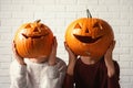 Women holding Halloween pumpkin head jack lanterns