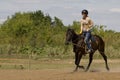 Women is horse riding - red hair girl in summer meadow Royalty Free Stock Photo