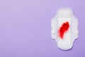 Women hygiene products or Sanitary pad with red feather on colored background. Pastel color. Closeup. Empty place for