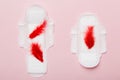 Women hygiene products or Sanitary pad with red feather on colored background. Pastel color. Closeup. Empty place for