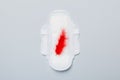 Women hygiene products or Sanitary pad with red feather on colored background. Pastel color. Closeup. Empty place for