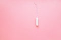 Women intimate hygiene product - sanitary tampon on pink background.