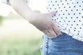 Women in jeans standing in the park, hand in pocket