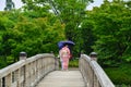 Women in kimono walking on wooden bridge