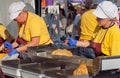 Women on kitchen of restaurant cooking fried food like the pies