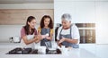 Women in kitchen teaching girl baking cake or cookies for family. Happy grandmother, mom and young child learning with Royalty Free Stock Photo