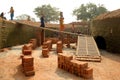 The women labours are carrying clay bricks to burn.