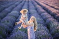 Women on lavander field with baby in dress, blond long hair feel happy