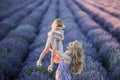 Women on lavander field with baby in dress, blond long hair feel happy