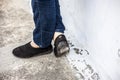 Women legs or female legs shod in black colored shoes and blue colored jeans.