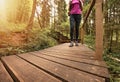 Women legs walking on wooden eco trail in forest. Active healthy tourism outdoors Royalty Free Stock Photo