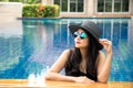 Women lifestyle relaxing near luxury swimming pool sunbath, summer day at the beach resort in the hotel. Royalty Free Stock Photo