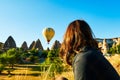 Women looking Hot Air balloon over blue turquoise sky in Cappadocia Turkey at sunrise