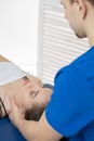 The woman is lying on the couch, and the doctor makes a diagnosis of the occipital part of the head. Manual therapy