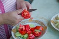 Women make salad .Dieting, healthy food, weight losing, well-being. Overweight fat woman slicing a tomato for salad Royalty Free Stock Photo