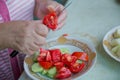 Women make salad .Dieting, healthy food, weight losing, well-being. Overweight fat woman slicing a tomato for salad. Tomatoes cut Royalty Free Stock Photo