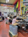 Women making fortune cookies at Golden Gate Fortune Cookie Company. Chinatown, San Francisco, California, USA