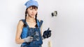 Women in the male profession: A girl repairs an electrical switch with a screwdriver and pliers. Royalty Free Stock Photo