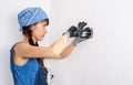 Women in the male profession: A girl repairs an electrical switch with a screwdriver and pliers. Royalty Free Stock Photo