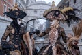 Women in masks and costumes, with Bridge of Sighs behind, at Venice Carnival Royalty Free Stock Photo