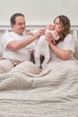 A woman and a man hold a newborn baby on a bed. Father and mother with a child boy, happy parents and an infant baby in a home Royalty Free Stock Photo