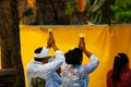 Women and men pray together in a typical sacred celebration at the Taman Ayun temple on the island of Bali