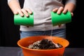 Women mixing ground with minerals in container for plant