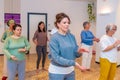 Women moving coordinated join hands in a qi gong class