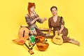 Women musicians in dresses with musical instruments on a yellow stuts Royalty Free Stock Photo