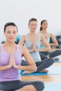 Women in Namaste position with eyes closed at fitness studio Royalty Free Stock Photo