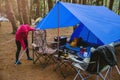 Women Nature tourism, camping in the middle of the pine forest. Adjusting and pulling the tent rope