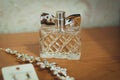 Women parfume in glass clear bottle near golden bride accessories for hair