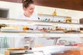 Women in pastry shop filling up sales display with pies Royalty Free Stock Photo