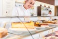 Women in pastry shop filling up sales display with pies Royalty Free Stock Photo