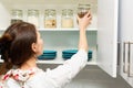 Women picking an item from storage hutch. Smart kitchen organization concept