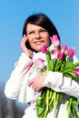 Women with pink tulips talking by a cellular Royalty Free Stock Photo