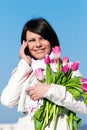 Women with pink tulips talking by a cellular Royalty Free Stock Photo