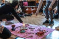 Women placing objects around a candle on a blanket for a ceremony of intent