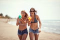 Women  pointing with water-guns on sandy beach Royalty Free Stock Photo