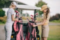 women in polos and caps with golf equipment at golf course Royalty Free Stock Photo