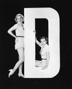 Women posing with huge letter D Royalty Free Stock Photo