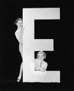 Women posing with huge letter E