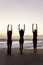 Women Practice Yoga on Beach At Sunrise or Sunset Royalty Free Stock Photo