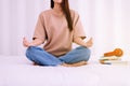 Women practicing doing yoga meditation sitting in bedroom,Workout exercise after waking up in morning,lotus position Royalty Free Stock Photo