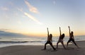 Women Practicing Yoga at Beach Sunrise or Sunset Royalty Free Stock Photo