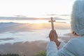 Women pray to god with the cross on the mountain background with morning sunrise. Woman Pray for god blessing to wishing have a