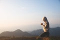 A women is praying to God on the mountain. Praying hands with faith in religion and belief in God on blessing background. Power of Royalty Free Stock Photo