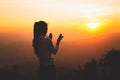 A women is praying to God on the mountain. Praying hands with faith in religion and belief in God on blessing background. Power of Royalty Free Stock Photo