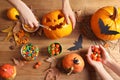 Women preparing Halloween pumpkin head jack lantern and holiday decorations on wooden table Royalty Free Stock Photo