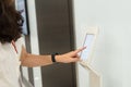 Women press number on access control to unlock elevator floor and choose the floor